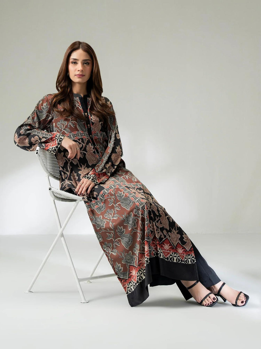 Woman wearing limelight pakistani silk shirt sat on chair with white background