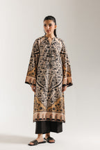 Woman sitting on a chair wearing ethnic pakistani a patterned outfit against a white background