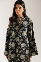 Woman wearing ethnic pakistani black floral patterned dress against a white background