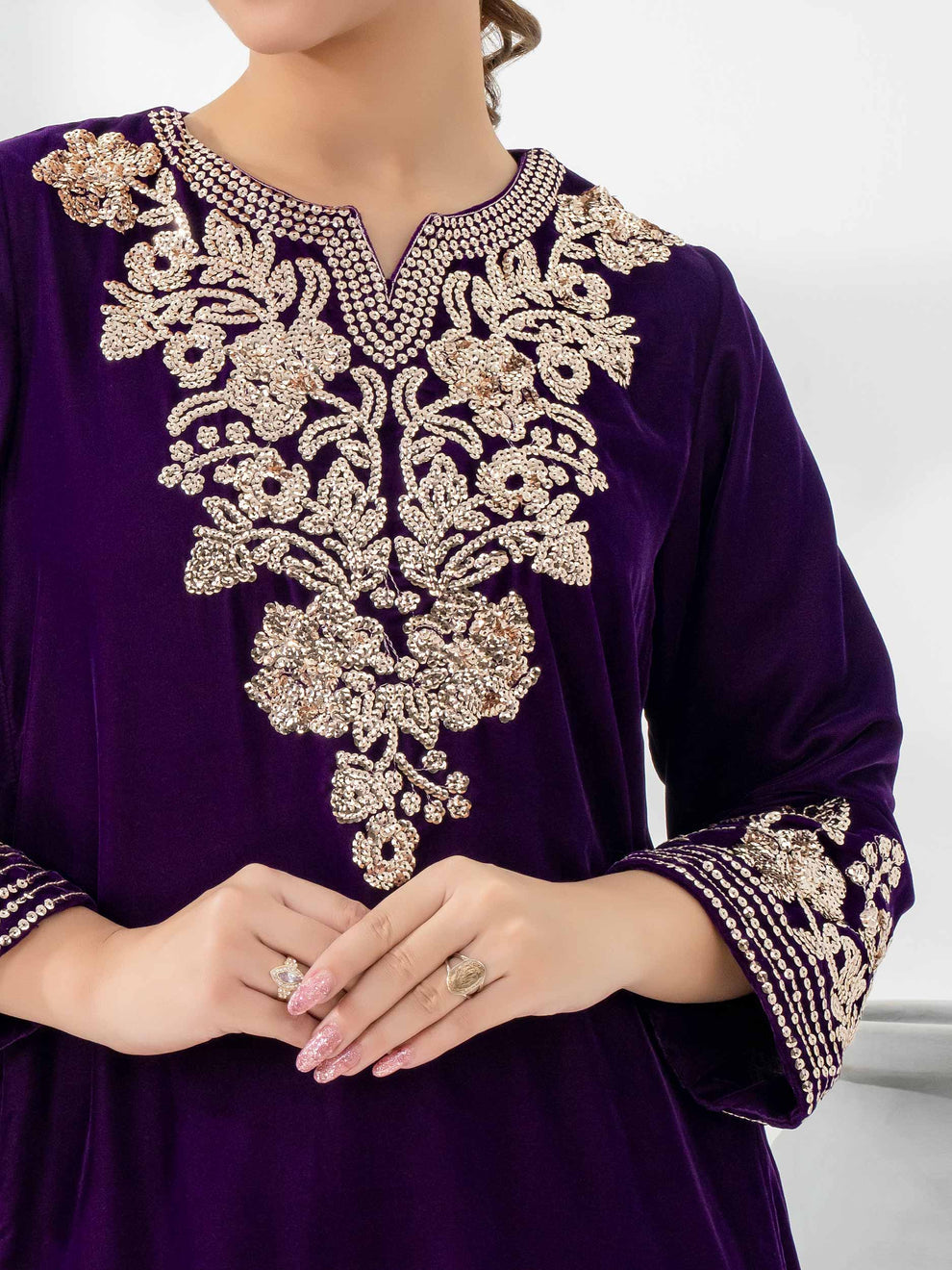 Woman wearing a purple velvet suit by limelight background white 