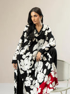 Woman wearing a black and white floral dress with a red bottom section, sitting on a chair.