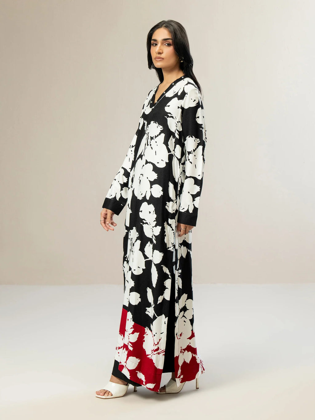 Woman wearing a black floral dress with a neutral background