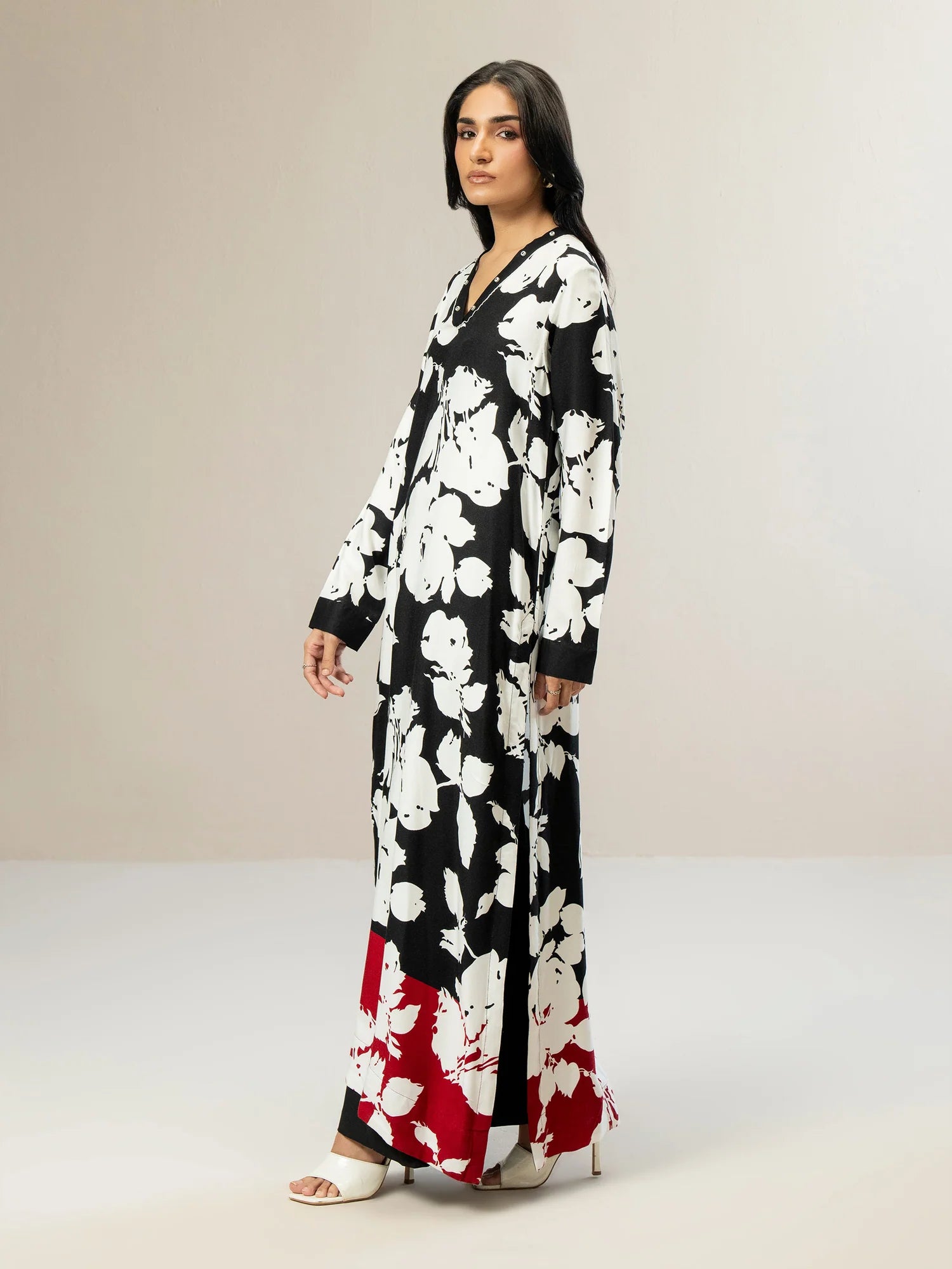 Woman wearing a black floral dress with a neutral background