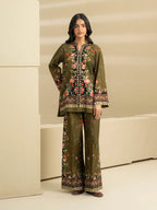 Woman wearing a green floral embroidered outfit in a minimalistic setting