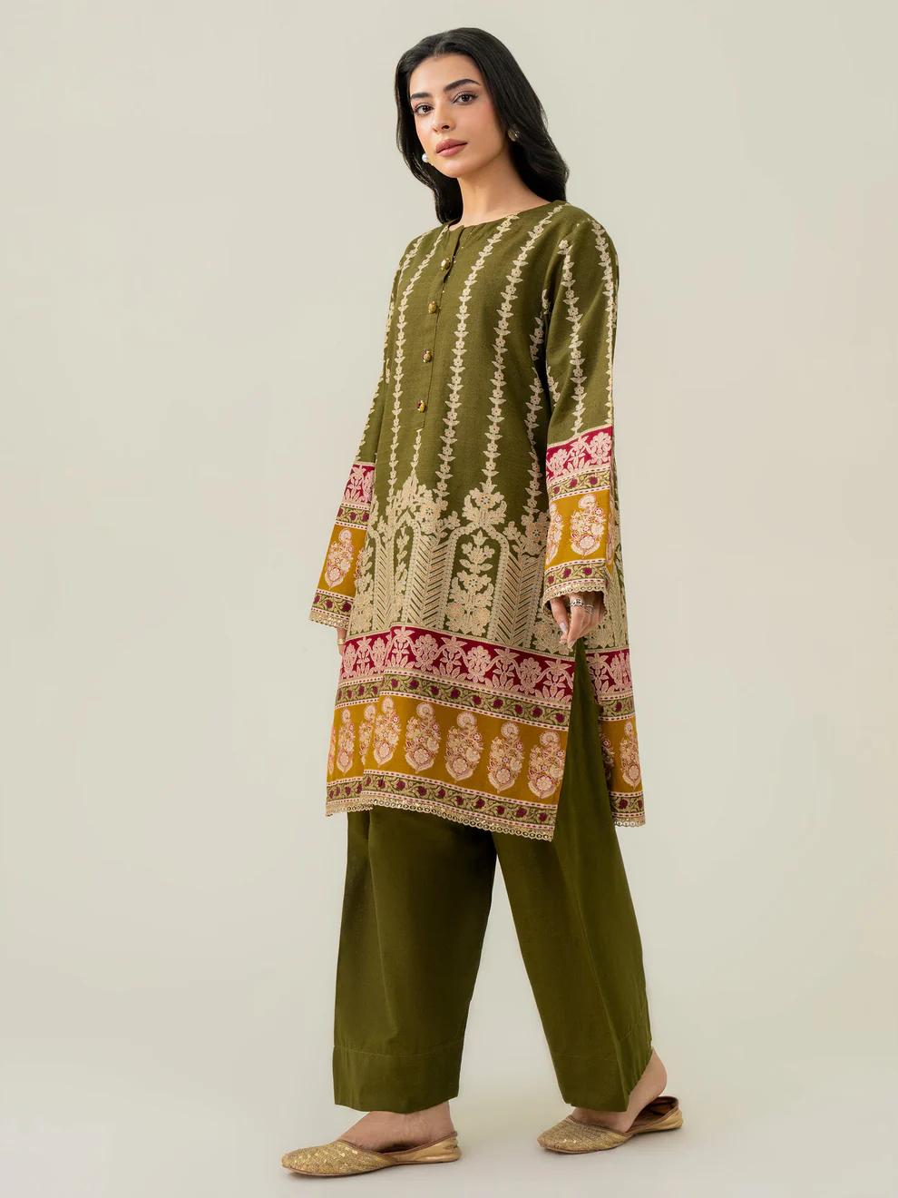 Woman wearing a green embroidered kurta with pants on a white background