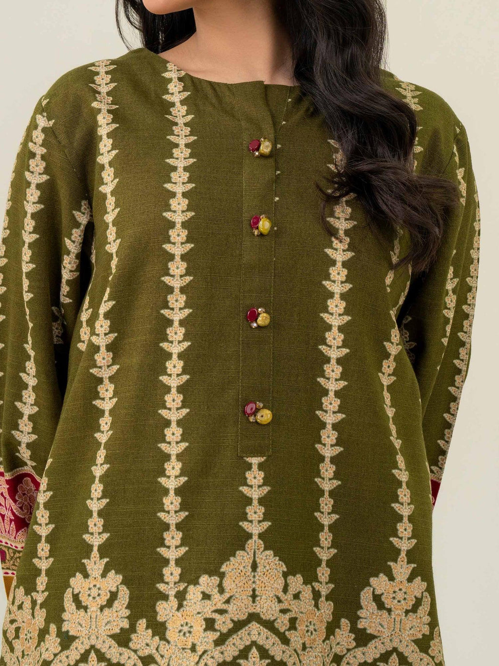 Green embroidered traditional outfit with a plain background