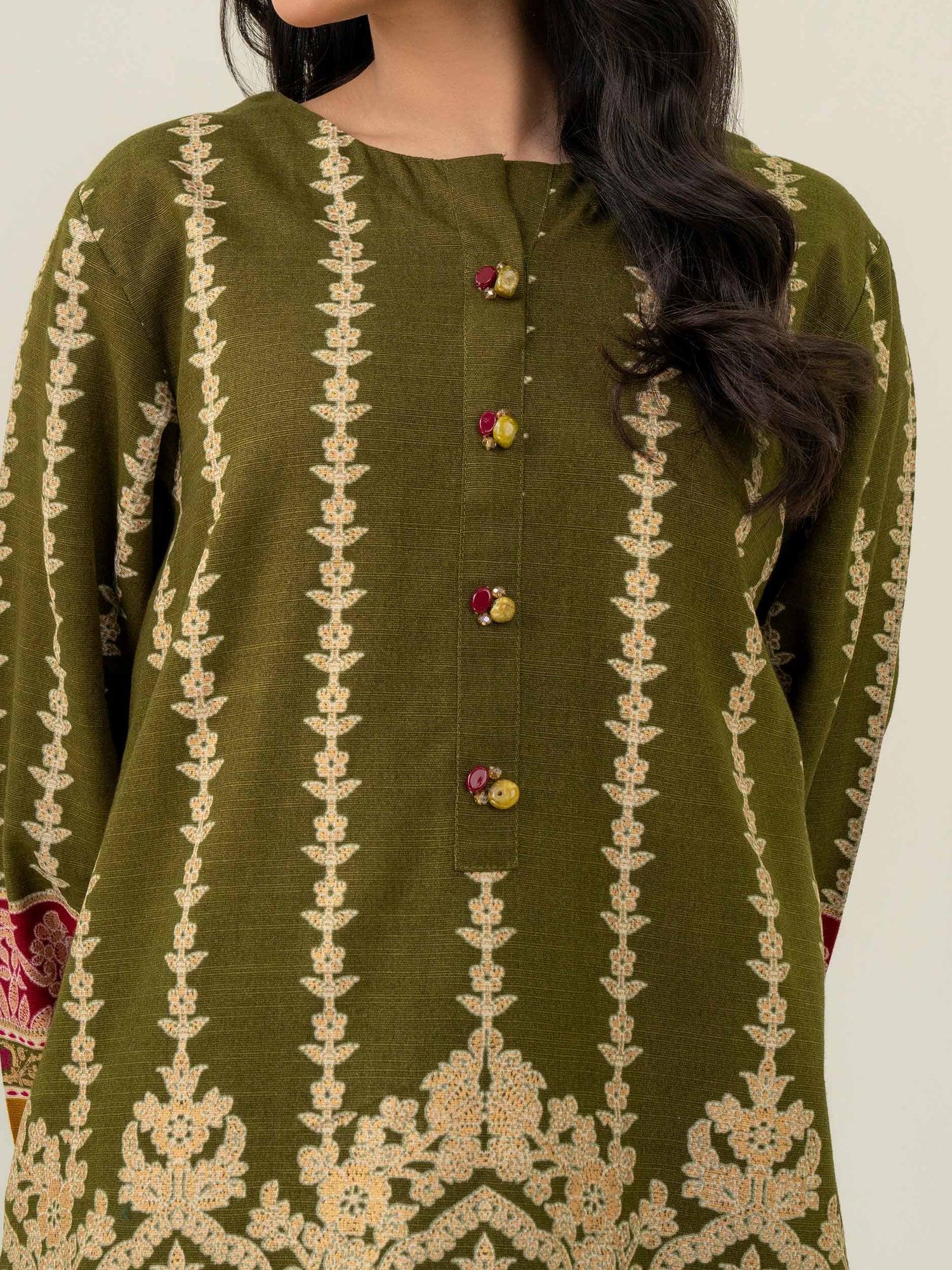 Green embroidered traditional outfit with a plain background