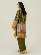 Woman wearing a traditional embroidered outfit with a plain background