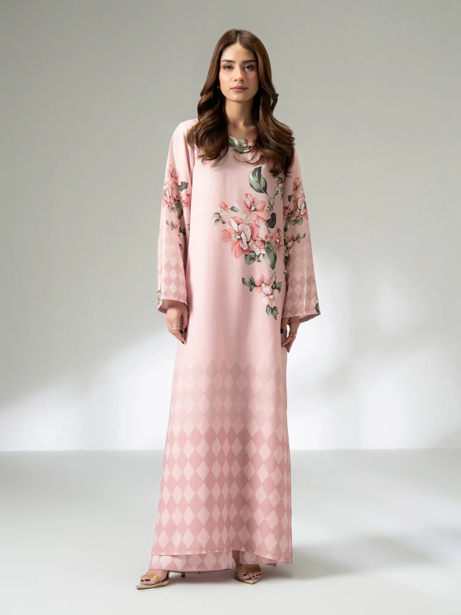 Woman wearing a pink floral dress on a white background