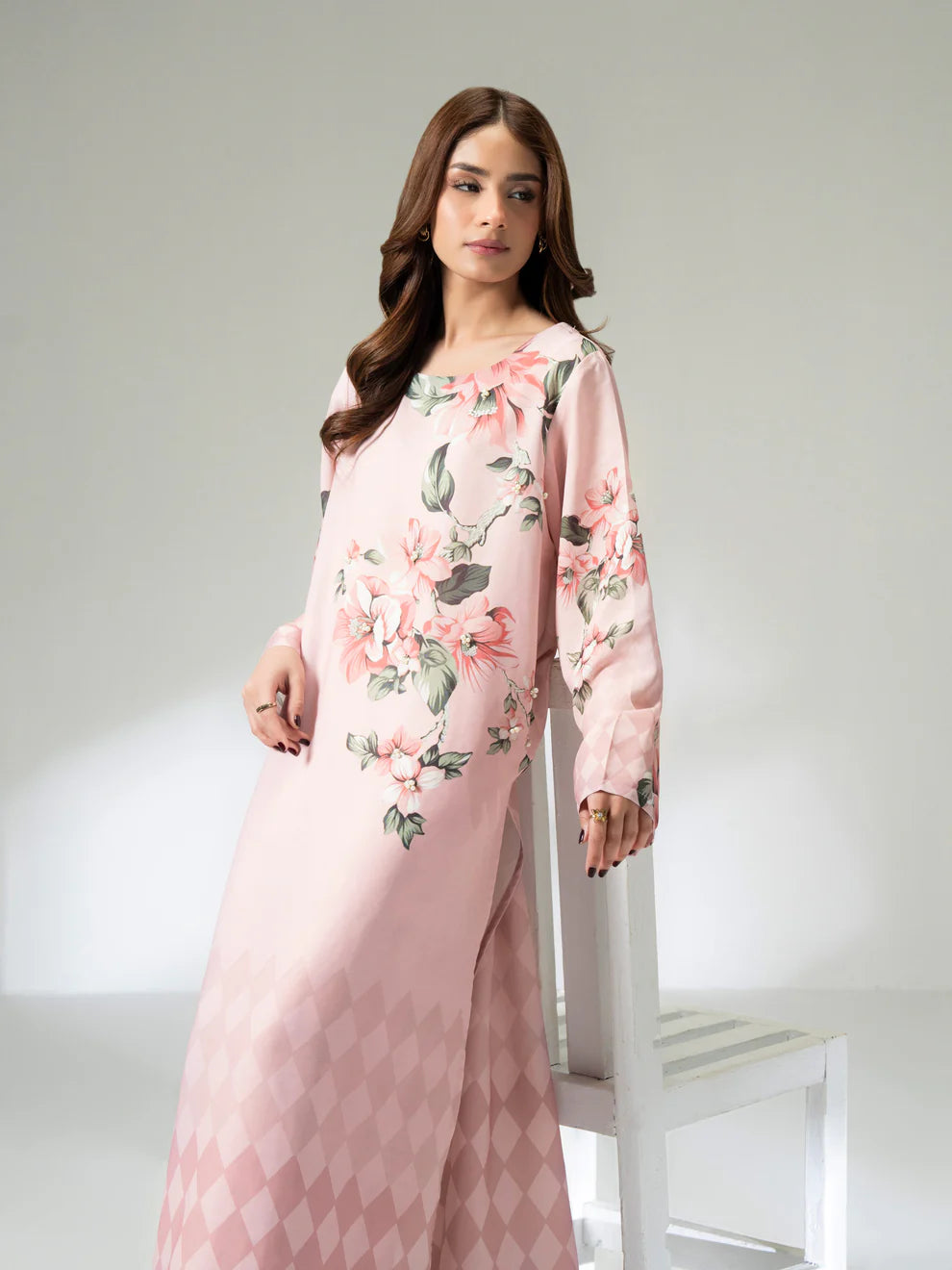 Woman wearing a pink floral dress against a white background