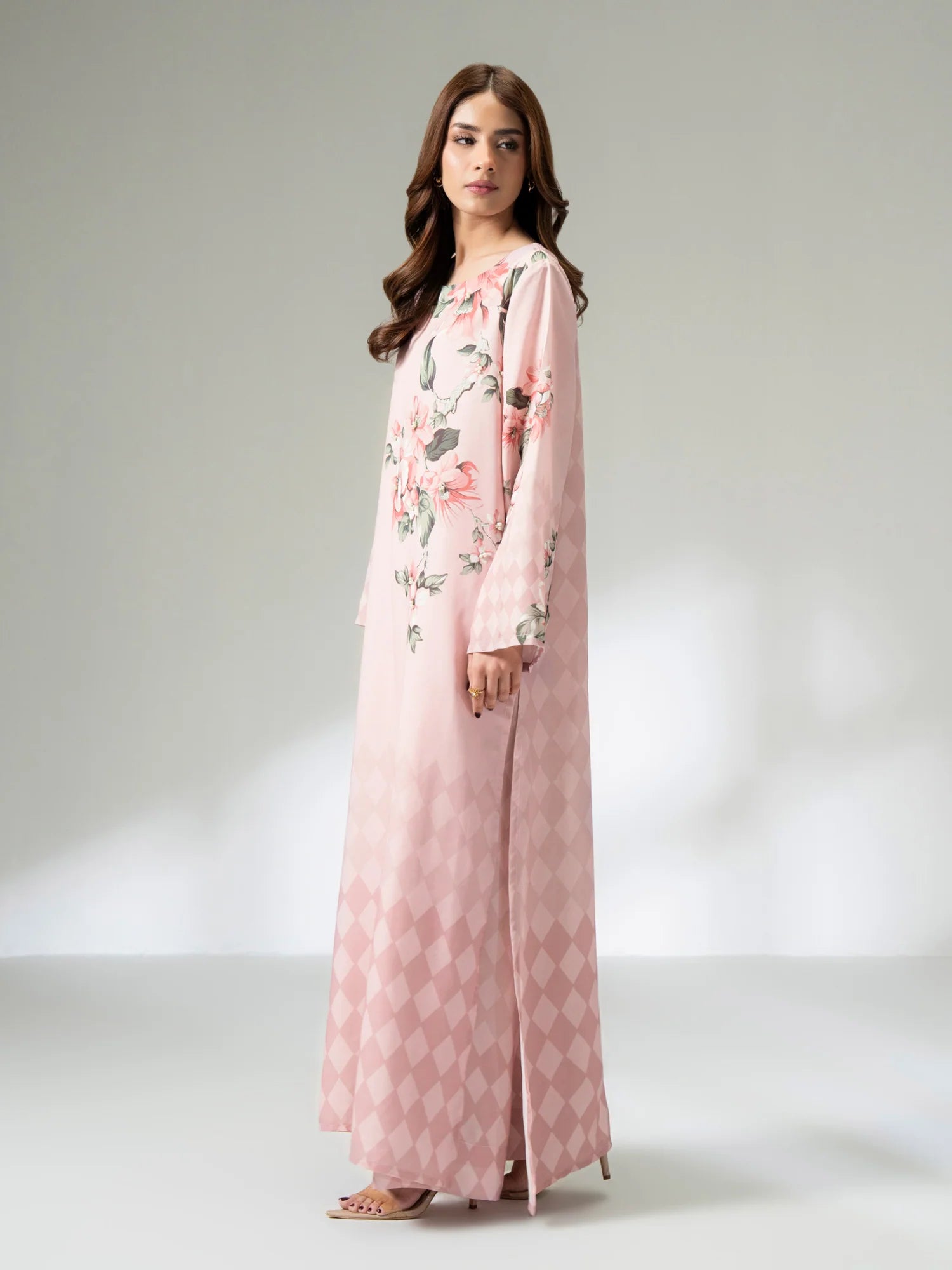 Woman wearing a pink floral dress with a matching jacket on a white background