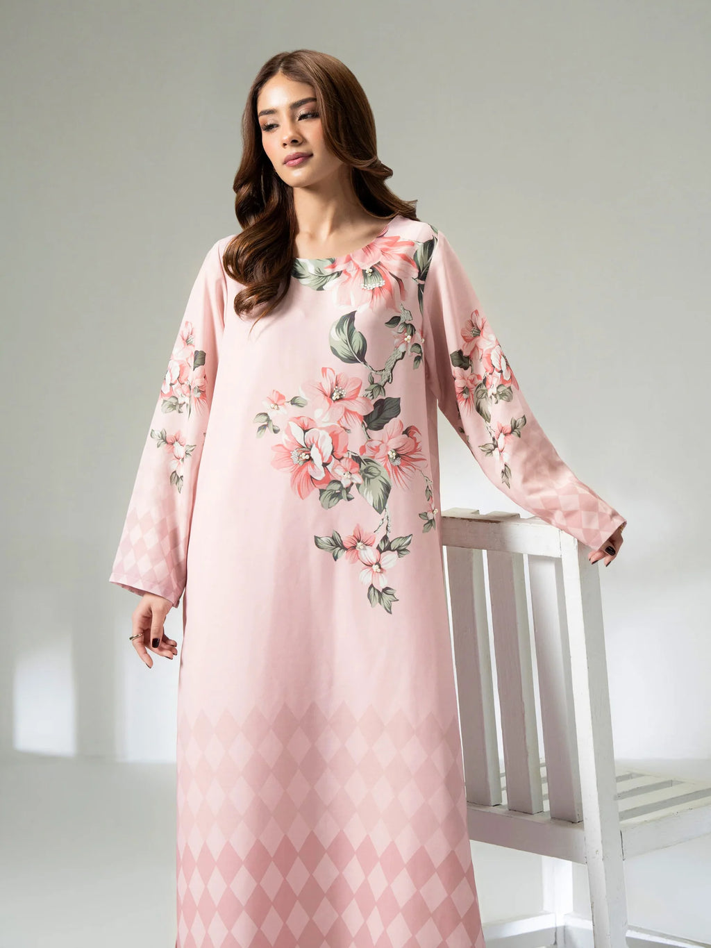 Woman wearing a pink floral dress against a white background
