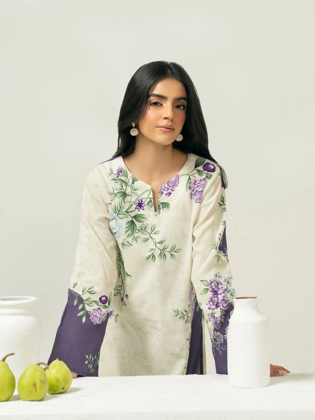 Woman wearing a floral embroidered outfit with a white background